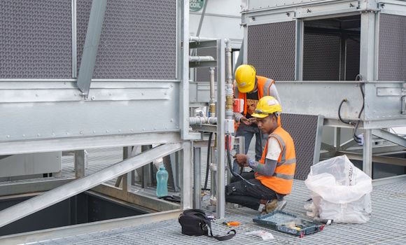 Technicians working on rooftop cooling towers